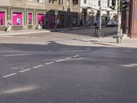 an empty road with shops and people walking on the side of it for some perspective