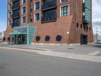 an empty road near two apartment buildings in a big city area with red brick walls