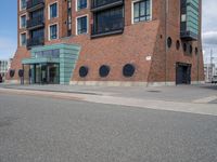 an empty road near two apartment buildings in a big city area with red brick walls