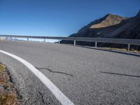 an image of an empty road with a bridge in the distance above it and hills on either side