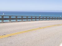 this is an empty road on the beach by the ocean's edge with no cars