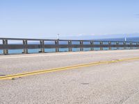 this is an empty road on the beach by the ocean's edge with no cars