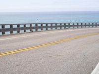 this is an empty road on the beach by the ocean's edge with no cars
