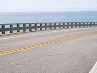 this is an empty road on the beach by the ocean's edge with no cars