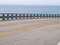 this is an empty road on the beach by the ocean's edge with no cars