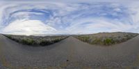 an empty open road on a cloudy day with a yellow dotted line at the bottom