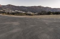 an empty road in the middle of the mountains with a stop sign in the distance