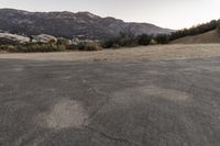 an empty road in the middle of the mountains with a stop sign in the distance
