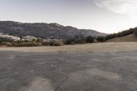 an empty road in the middle of the mountains with a stop sign in the distance