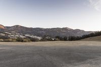 an empty road in the middle of the mountains with a stop sign in the distance