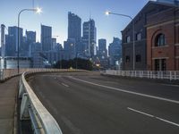 an empty road leads to a city skyline at dusk or dusk with traffic and lights on