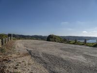 the road is wide and empty on a mountain side next to the ocean to the right