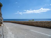 an empty road that has no traffic at all on it with a view over the ocean