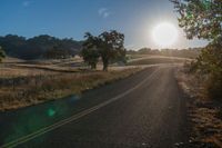 the sun shines brightly on a empty road in the countryside of southern california, usa