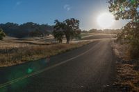 the sun shines brightly on a empty road in the countryside of southern california, usa