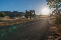 the sun shines brightly on a empty road in the countryside of southern california, usa