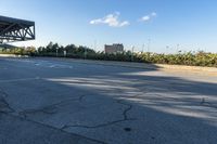 the empty road and curb outside the city building area has a large tire marks in it