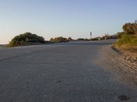 an empty road in the desert with no traffic on it, on the beach with many shrubs