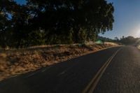 an empty road is seen through the lens of a car in motion down the side of the road