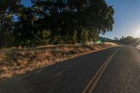 an empty road is seen through the lens of a car in motion down the side of the road