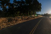 an empty road is seen through the lens of a car in motion down the side of the road