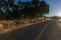 an empty road is seen through the lens of a car in motion down the side of the road