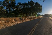 an empty road is seen through the lens of a car in motion down the side of the road