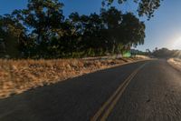 an empty road is seen through the lens of a car in motion down the side of the road