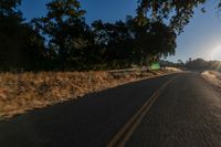 an empty road is seen through the lens of a car in motion down the side of the road