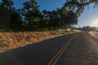 an empty road is seen through the lens of a car in motion down the side of the road