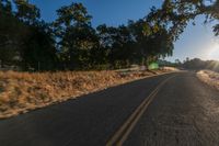 an empty road is seen through the lens of a car in motion down the side of the road