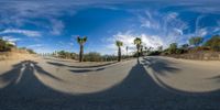 a long shadow falls over an empty road in the middle of a desert area of a residential complex