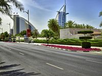 an empty road in front of the burjra in dubai, with a tall building to the side