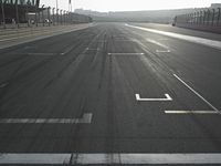a street view in the sunlight and sun setting on it with an empty road in the foreground