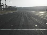 a street view in the sunlight and sun setting on it with an empty road in the foreground