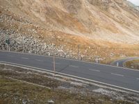 two lanes are shown with mountains behind them in this image with an empty road leading to the top and below