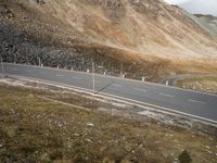 two lanes are shown with mountains behind them in this image with an empty road leading to the top and below