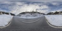 an empty road covered in snow with lots of snow on the ground and trees in the distance