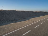 an empty road with several markings on the side and sand up to the side of it