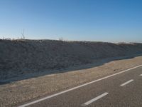 an empty road with several markings on the side and sand up to the side of it