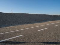 an empty road with several markings on the side and sand up to the side of it