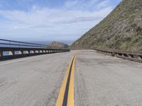 the road that leads into the ocean is empty on the side of the cliff to the ocean