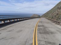 the road that leads into the ocean is empty on the side of the cliff to the ocean