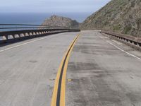 the road that leads into the ocean is empty on the side of the cliff to the ocean