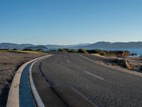 the road going down to the ocean is empty and clear as people look for something