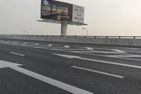 there is an empty road next to some lights and a billboard that looks like it has been taken over