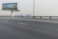 there is an empty road next to some lights and a billboard that looks like it has been taken over