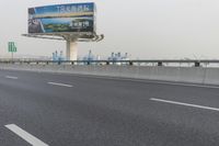 there is an empty road next to some lights and a billboard that looks like it has been taken over