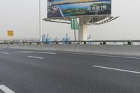 there is an empty road next to some lights and a billboard that looks like it has been taken over