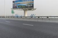 there is an empty road next to some lights and a billboard that looks like it has been taken over